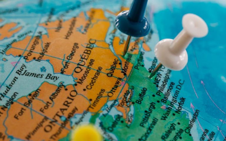 Detailed view of a globe with blue, white, and yellow pushpins marking locations.